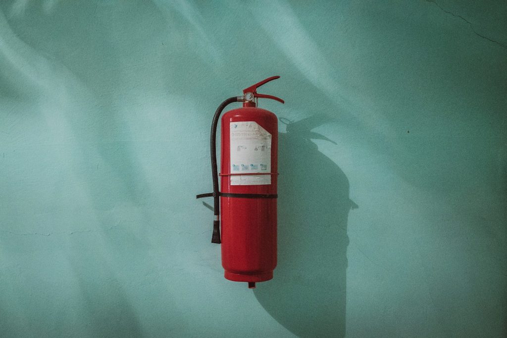 Rode brandblusser aan een groene muur