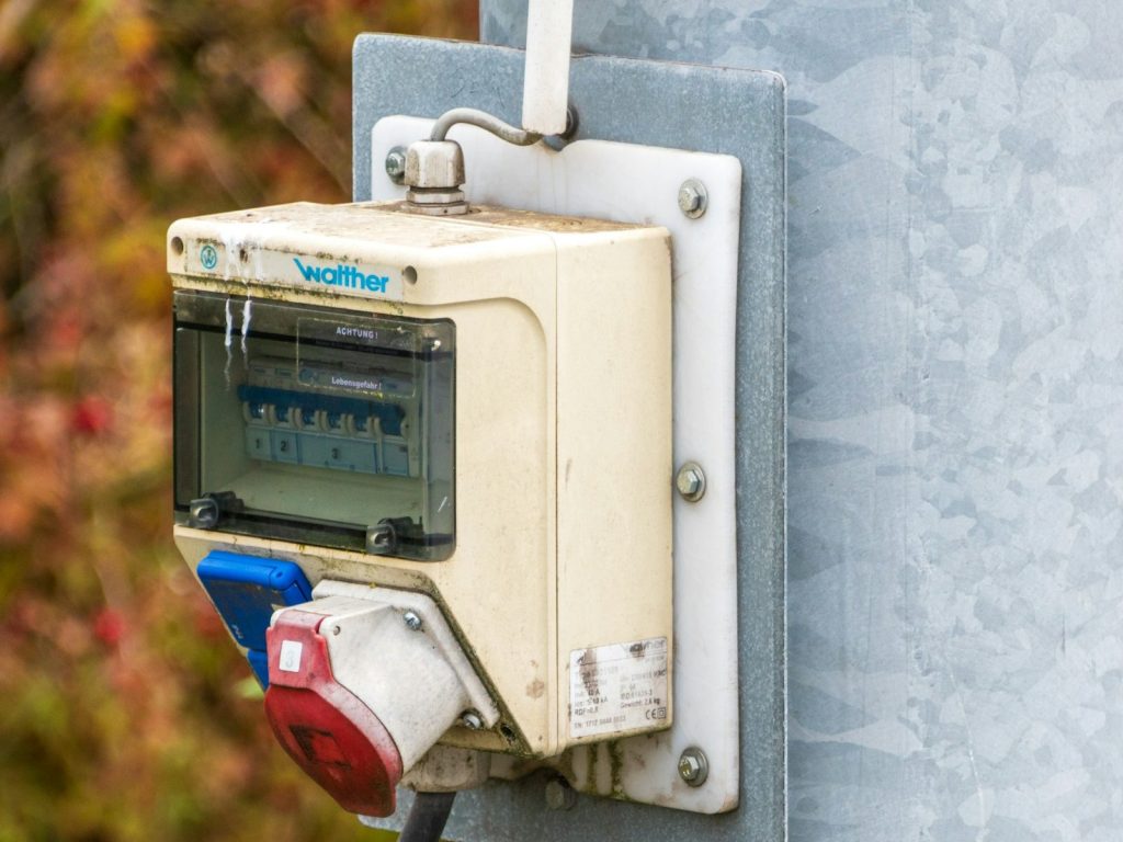 Verdeelkastje aan een paal met een rode CEE-contactdoos voor krachtstroom en een blauwe voor 230 volt