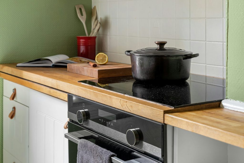 Elektrische kookplaat met een pan in een keuken met houten werkblad