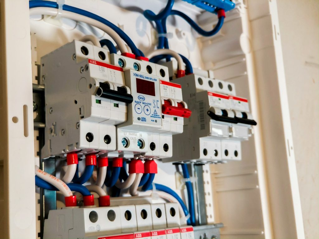 Geopende groepenkast met installatieautomaten, een spanningsrelais en bedrading