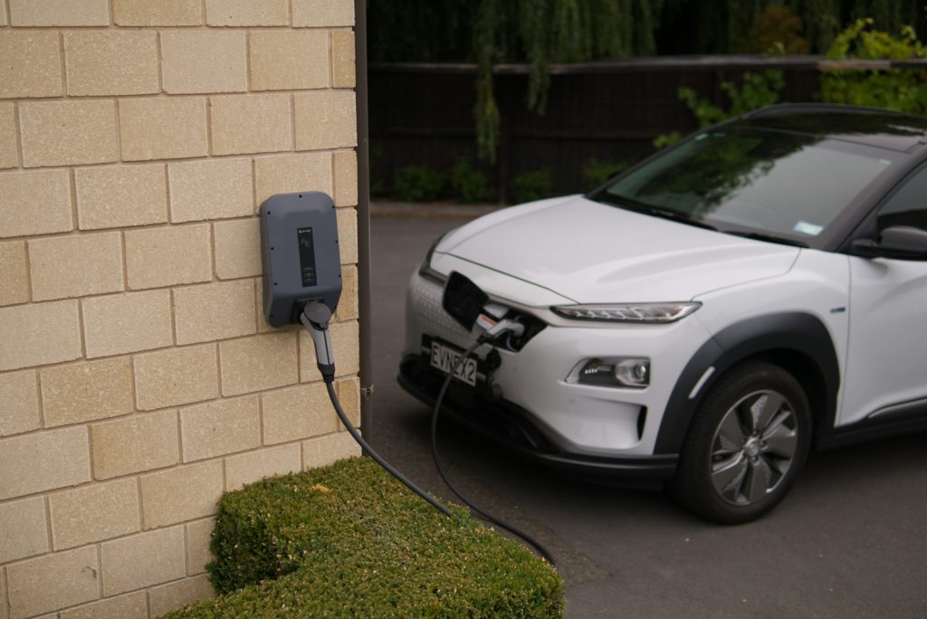 Laadpaal aan de gevel, met een elektrische auto aan de laadkabel