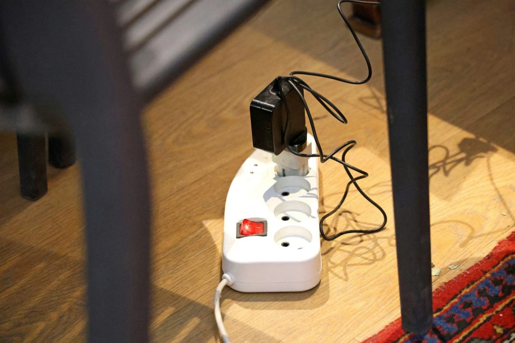 Stekkerdoos met stekkers en een aan-uitschakelaar op een houten vloer
