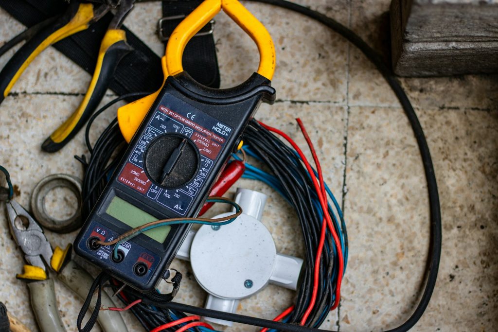 Stroomtang, kabels en gereedschap van een elektricien op de vloer